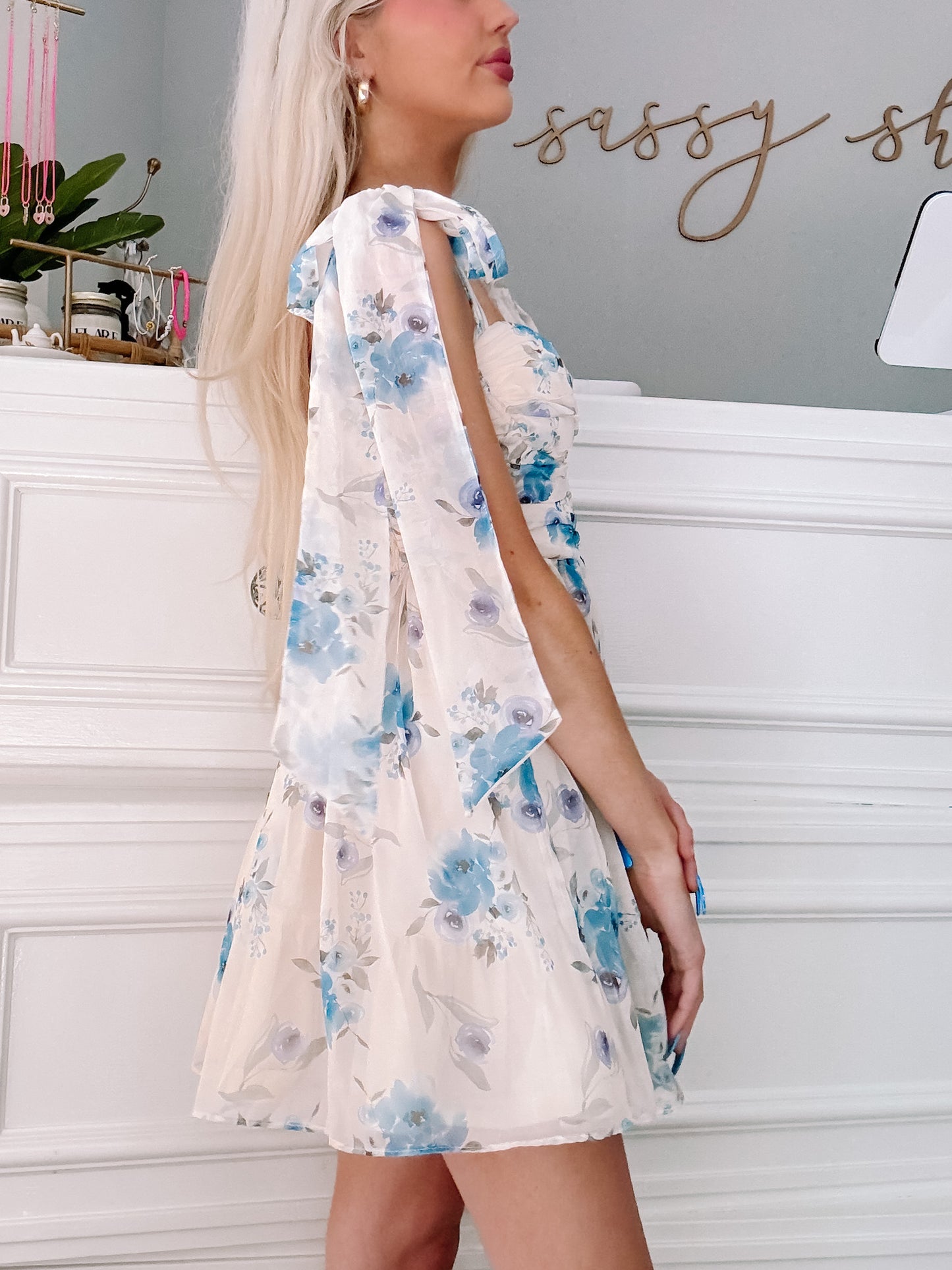 Floral mini dress; blue and white watercolor print, side view showcasing the bow straps.