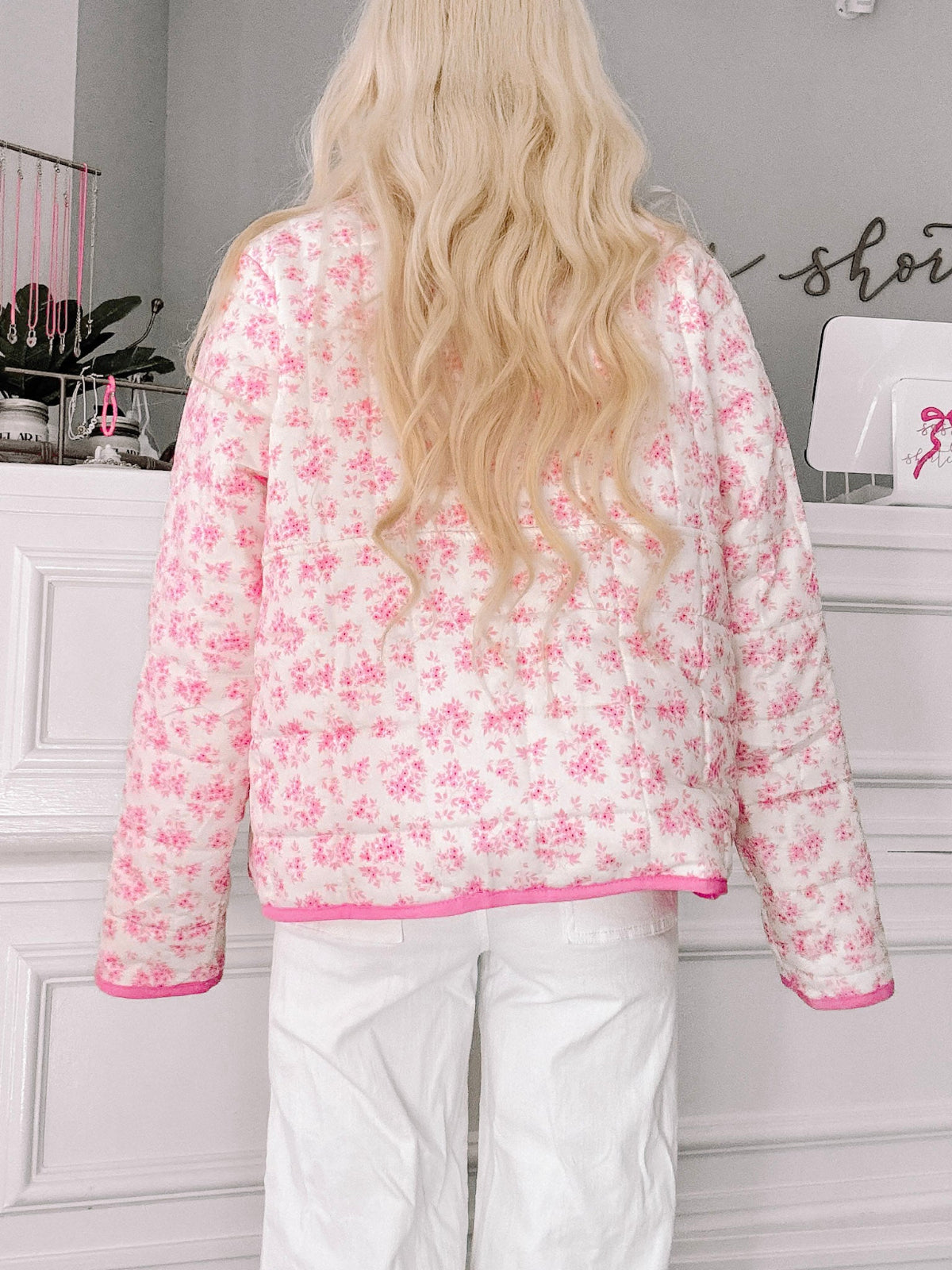 Floral Quilted Pullover from Sassy Shortcake - Person wearing a pink floral blouse with white pants in an indoor setting.