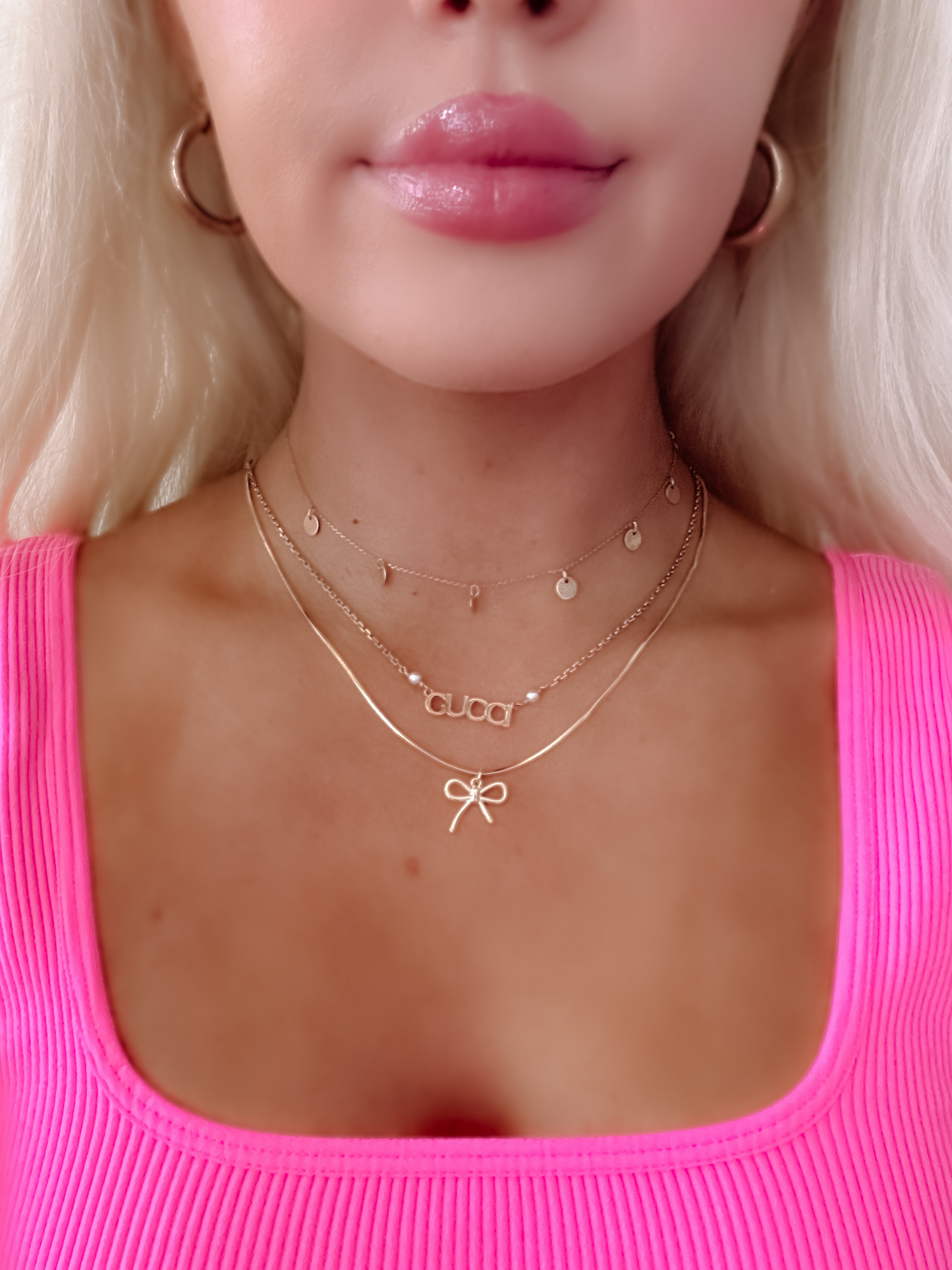 Gold Gia bow necklace layered with delicate chains.