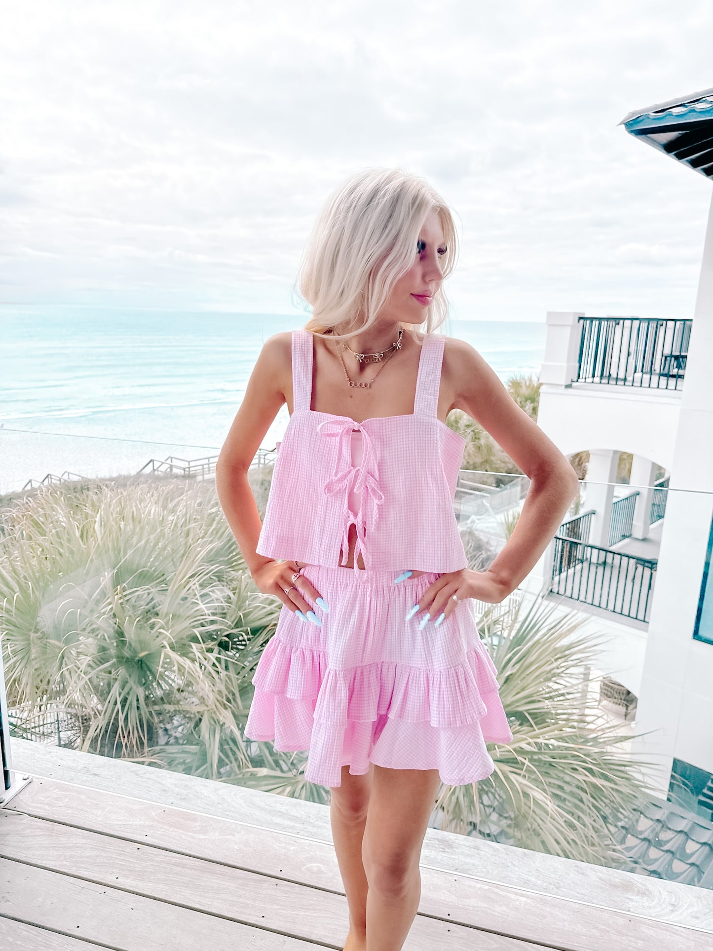 Full-body shot of two-piece pink gingham outfit with elastic waistband and crop fit.