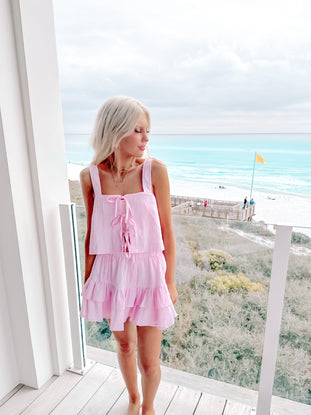 Front view of pink gingham set with self-tie top and ruffled skirt, styled for a picnic date.