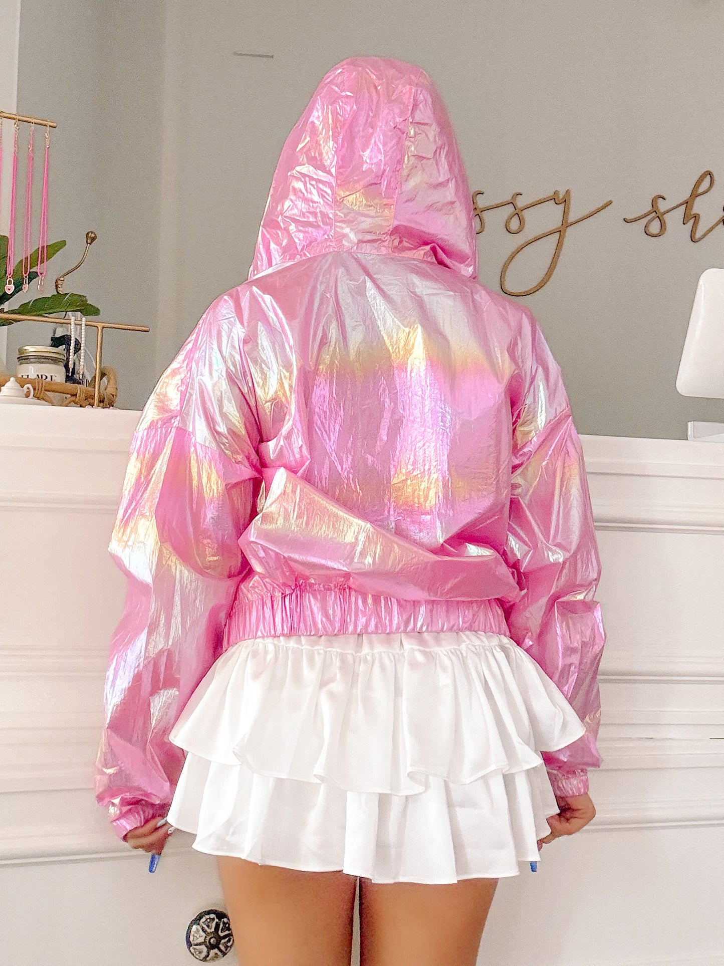 Pink iridescent jacket with a hoodie, shown from the back, paired with a white ruffled skirt.