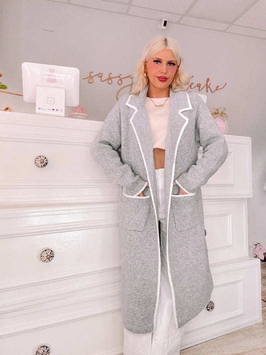 Model wearing a long gray coat with white trim from Sassy Shortcake.