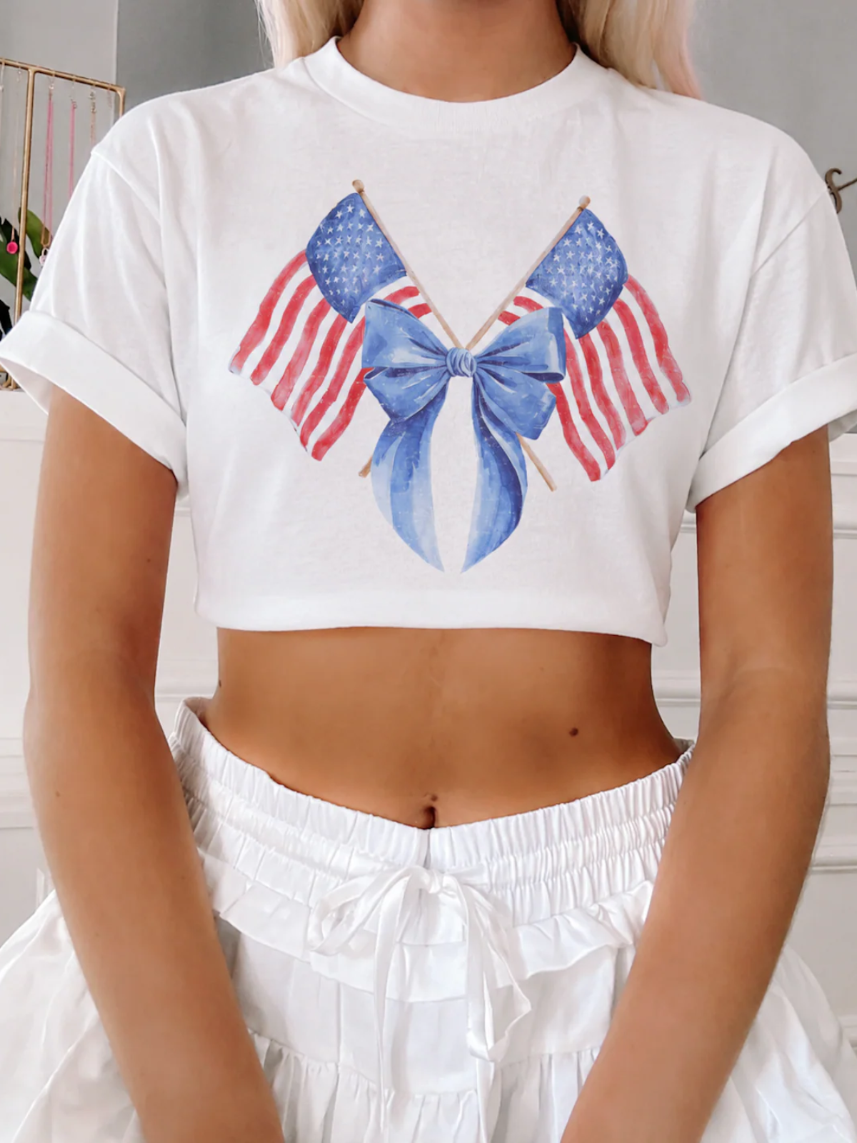 Close-up of the hand-painted watercolor flag and bow graphic on The Liberty Ribbon Tee by Sassy Shortcake