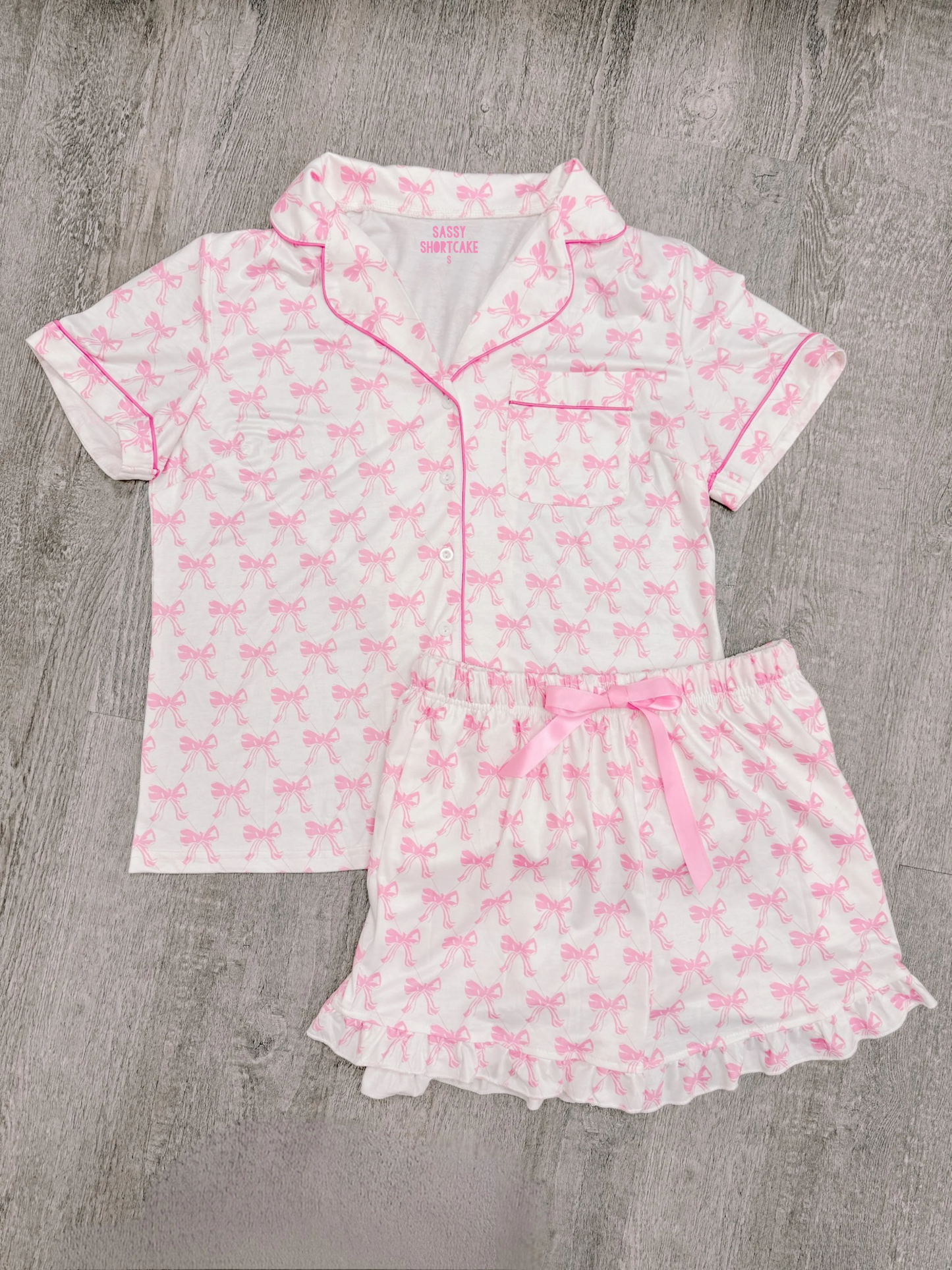 Pink bow print pajama set; short sleeves, shorts with ruffle trim.