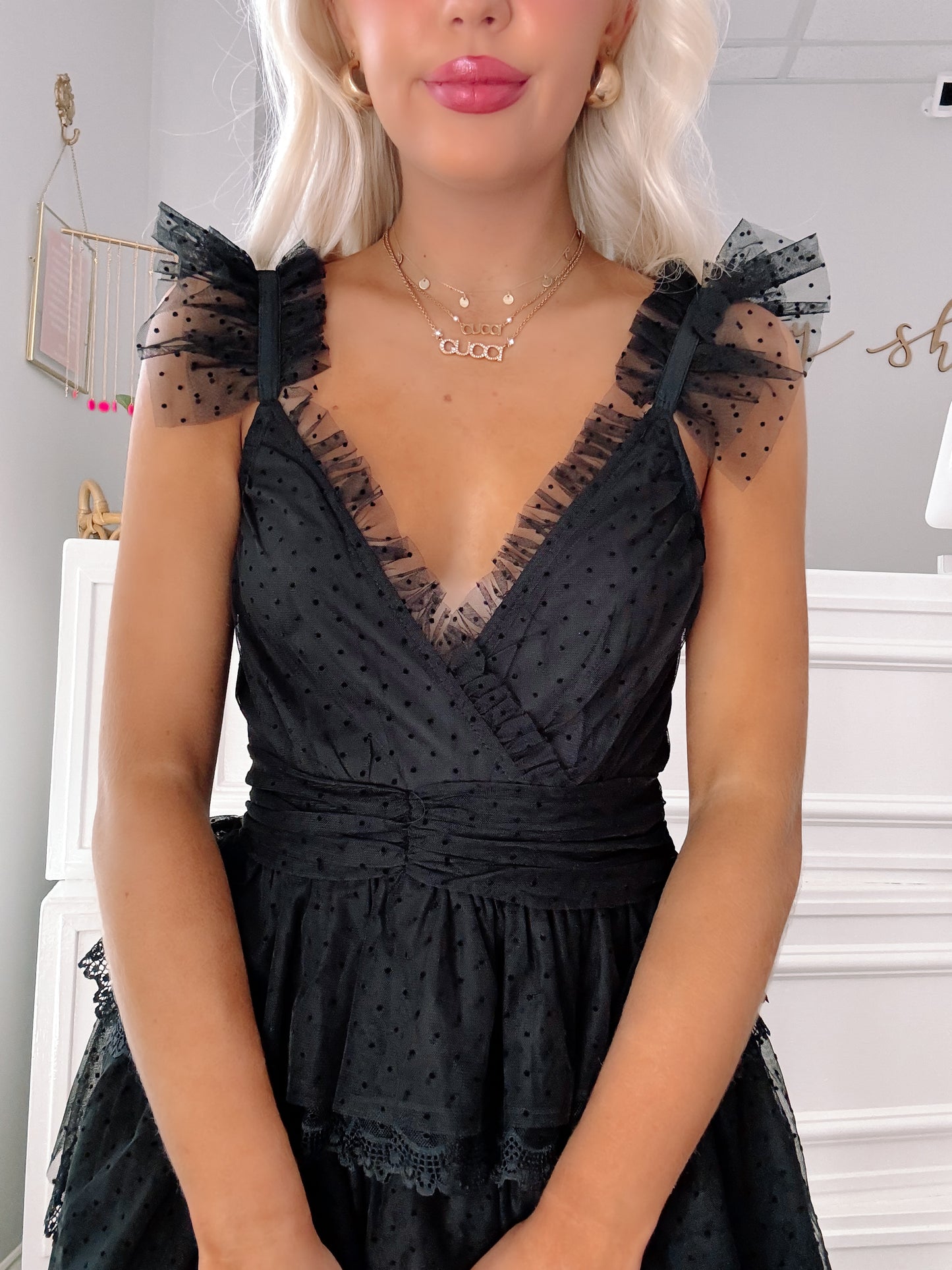 Black Swiss dot mini dress with ruffled sleeves and tiered lace trim.
