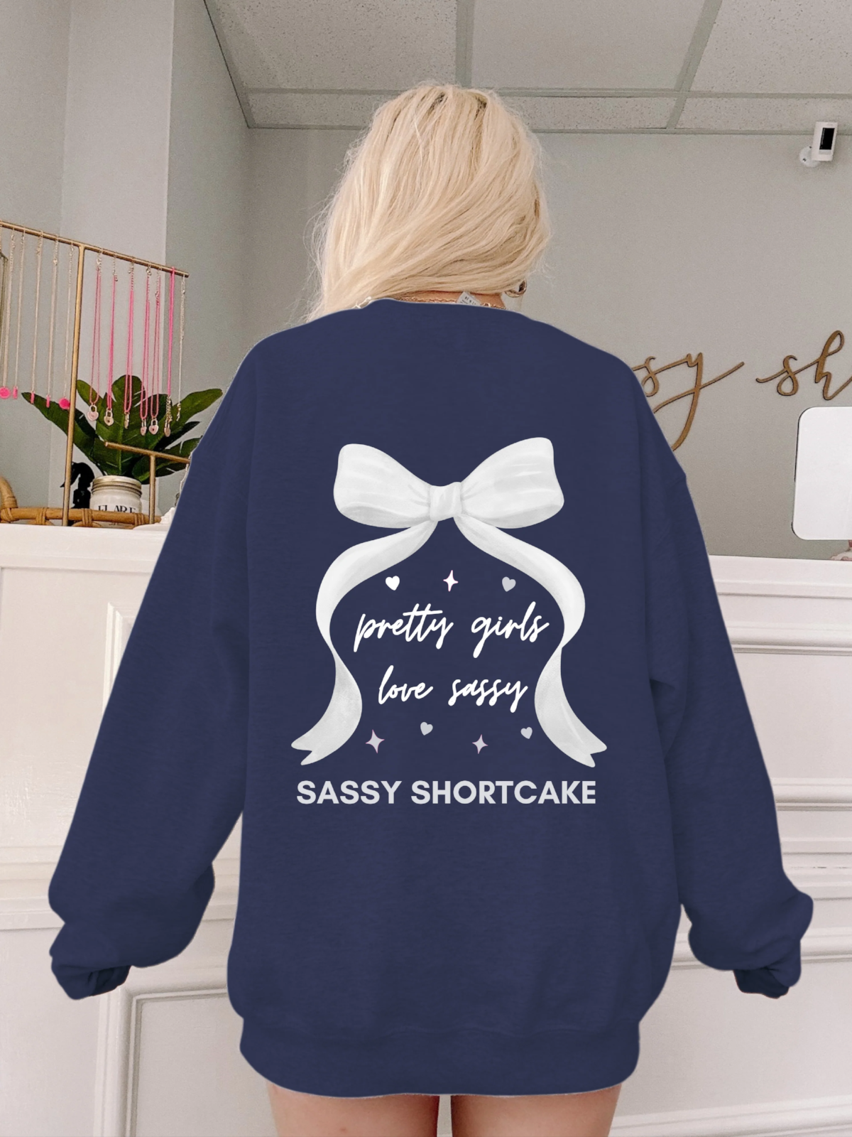 back view of model wearing navy bow crewneck from sassy shortcake