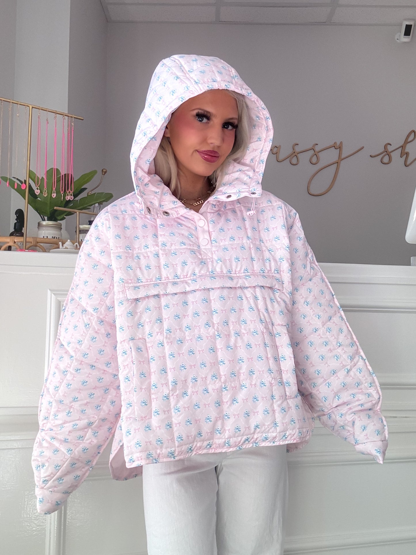 Pink quilted pullover with a floral pattern, model wearing in a boutique setting from Sassy Shortcake
