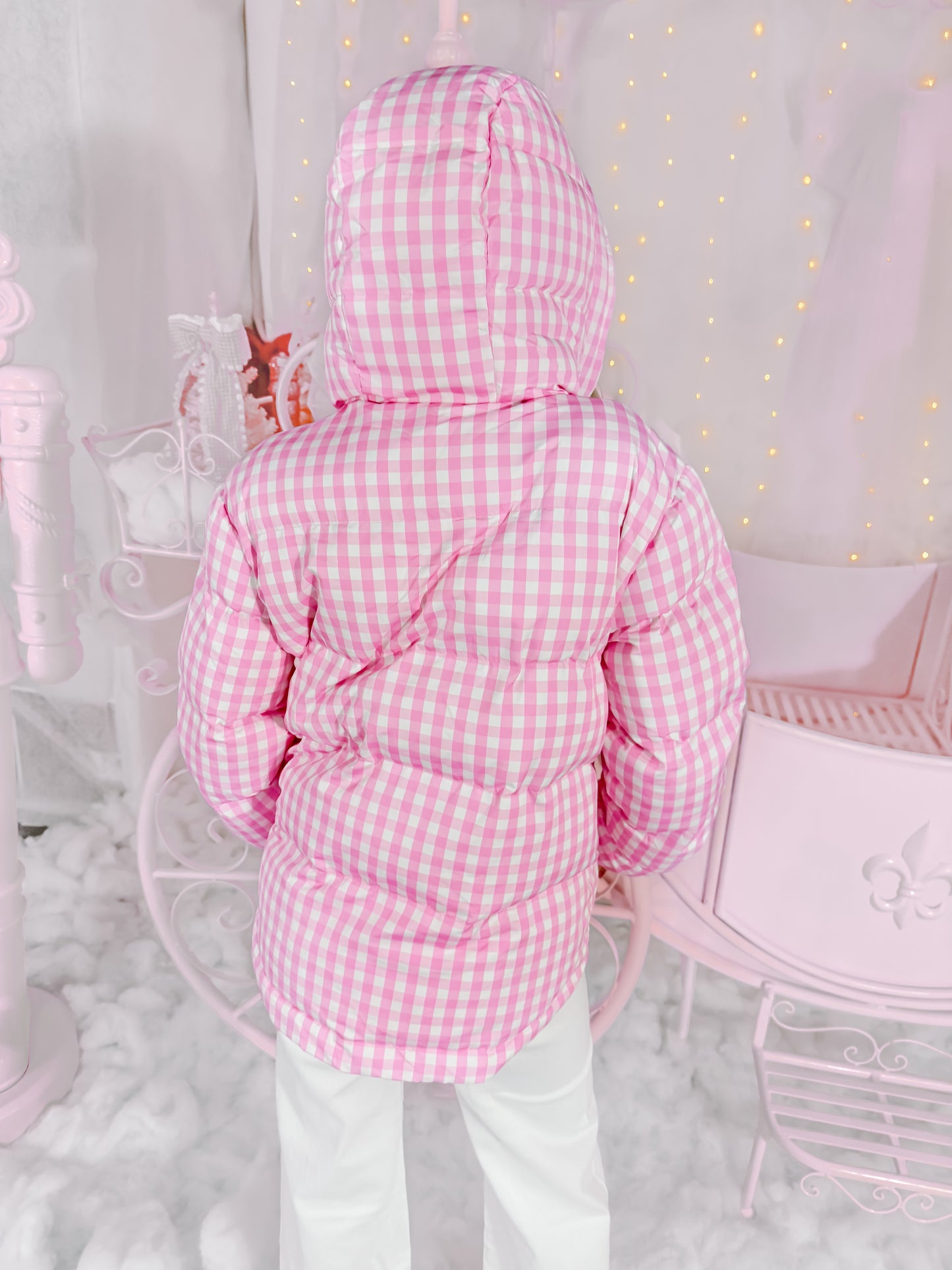 Pink gingham puffer jacket with a hood, shown from the back against a pastel pink backdrop.
