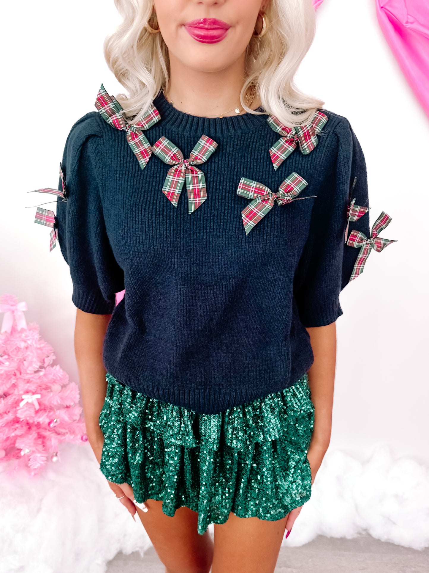 Navy blue Put a Bow On It sweater with red and green plaid bows.