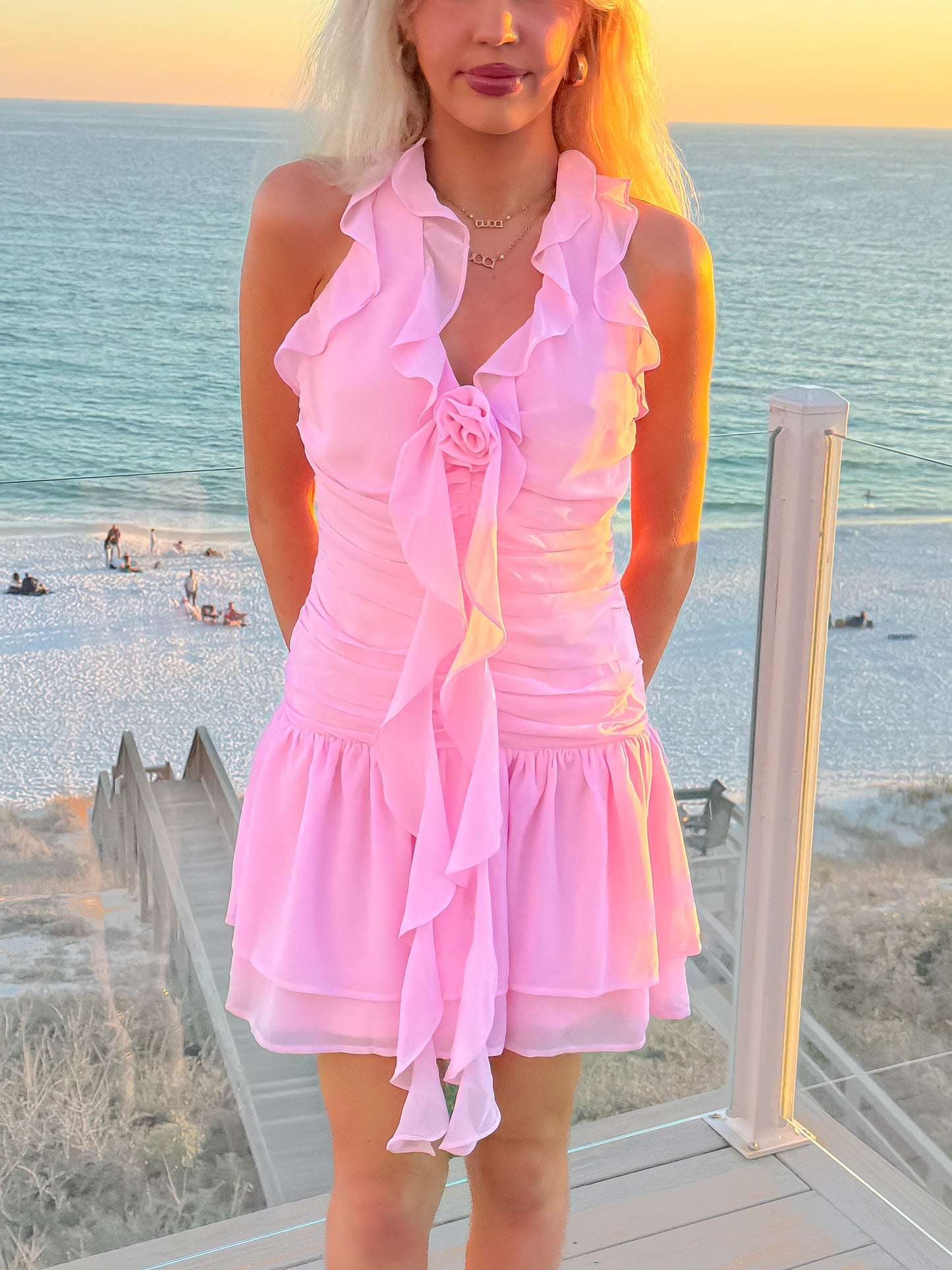 Pink halter tie neck dress with shirring and rosette front detail