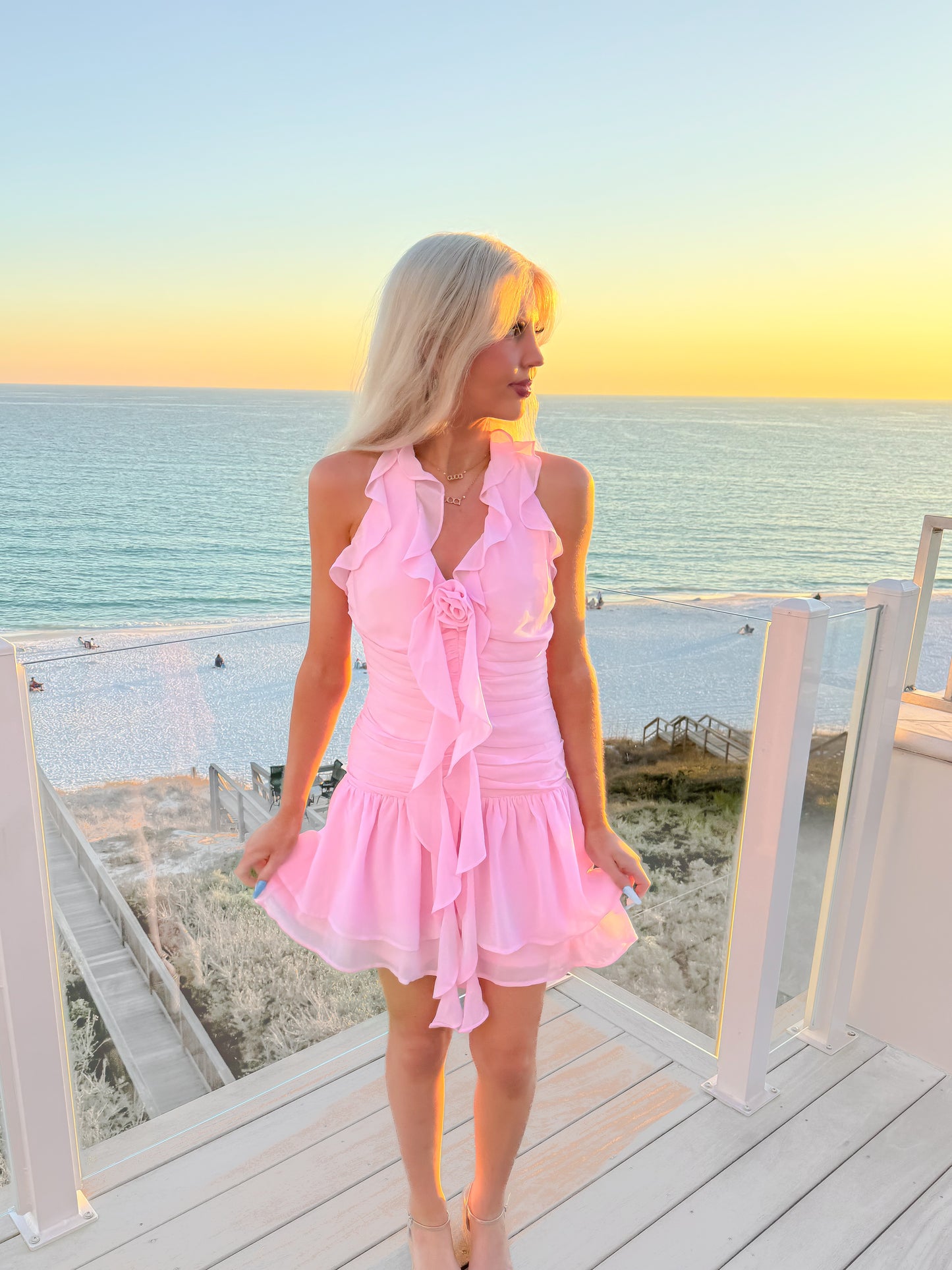 model wearing pink halter tie neck dress