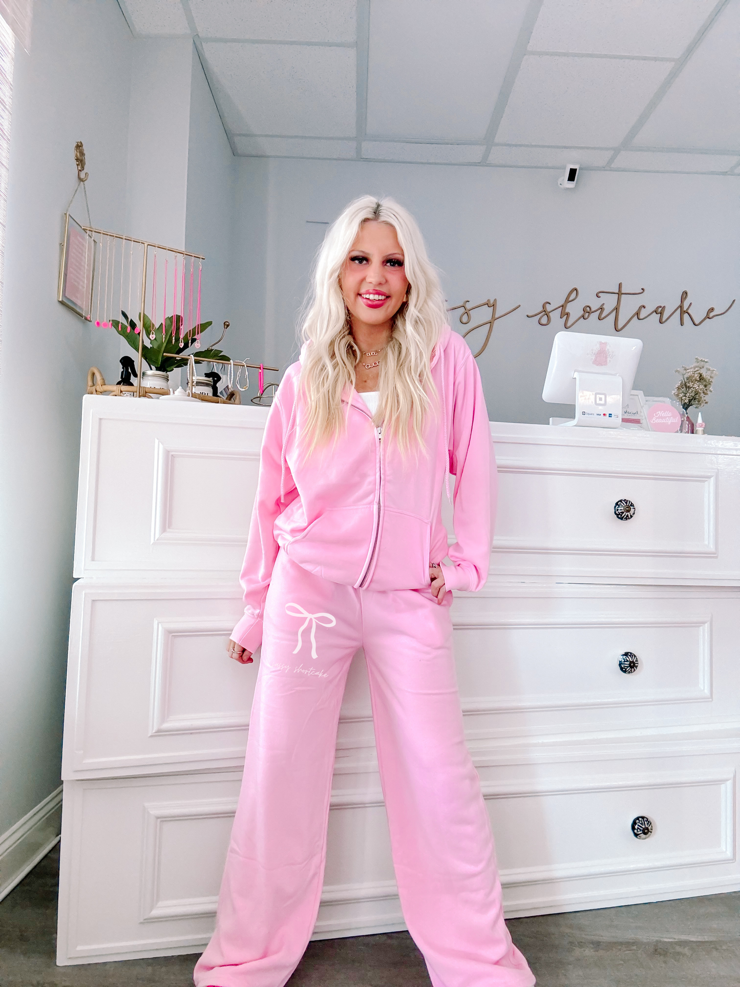 Sassy Bow Wideleg Sweatpants in Bubblegum Pink from Sassy Shortcake being modeled in the fron of the shop