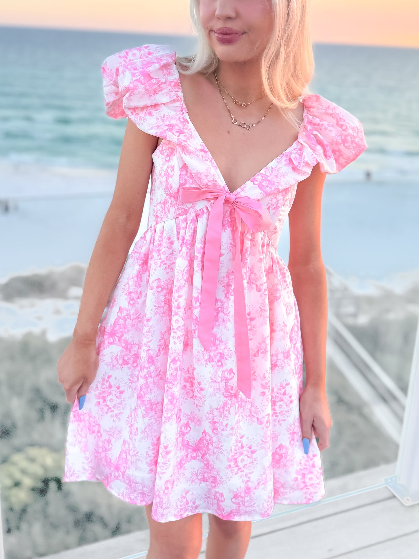 Storybook Toile Dress with pink floral print, flutter sleeves, and tie-front bow