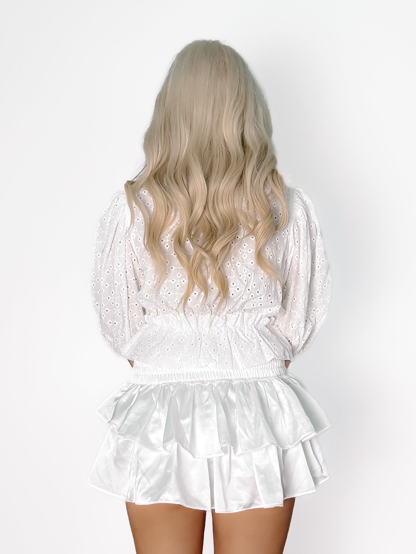 White eyelet top and satin mini skirt; rear view on model.
