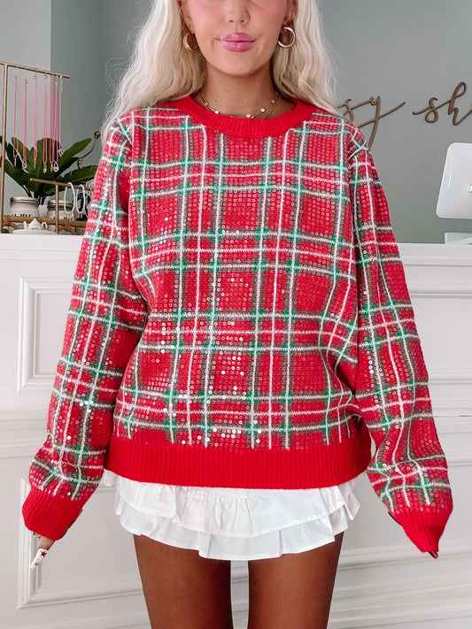Red and green sequined plaid sweater, casual holiday style.