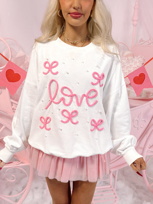 White Sweetheart Pearl Bow Crewneck sweater with pink embroidered "love" and bows.