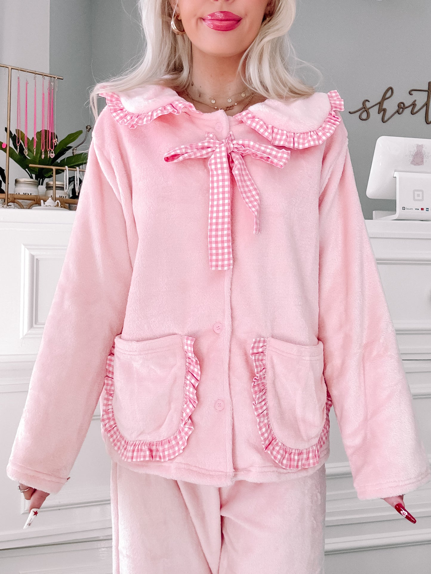 Pink plush pajama set with gingham trim and ruffled details.
