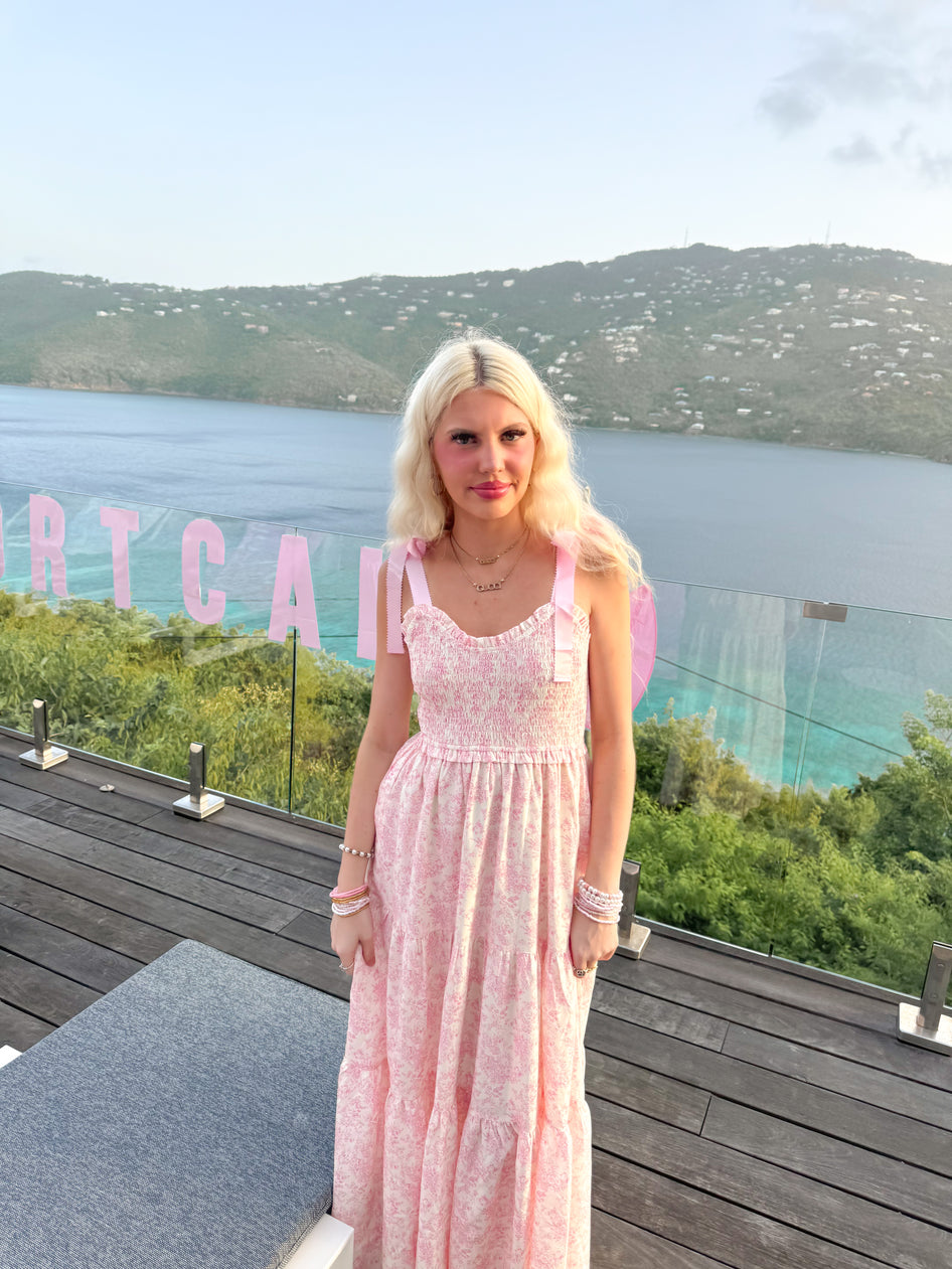 Model in Sassy Shortcake Sweet Pea pink floral maxi twirling to show tiered skirt — vacation-ready wedding guest dress.