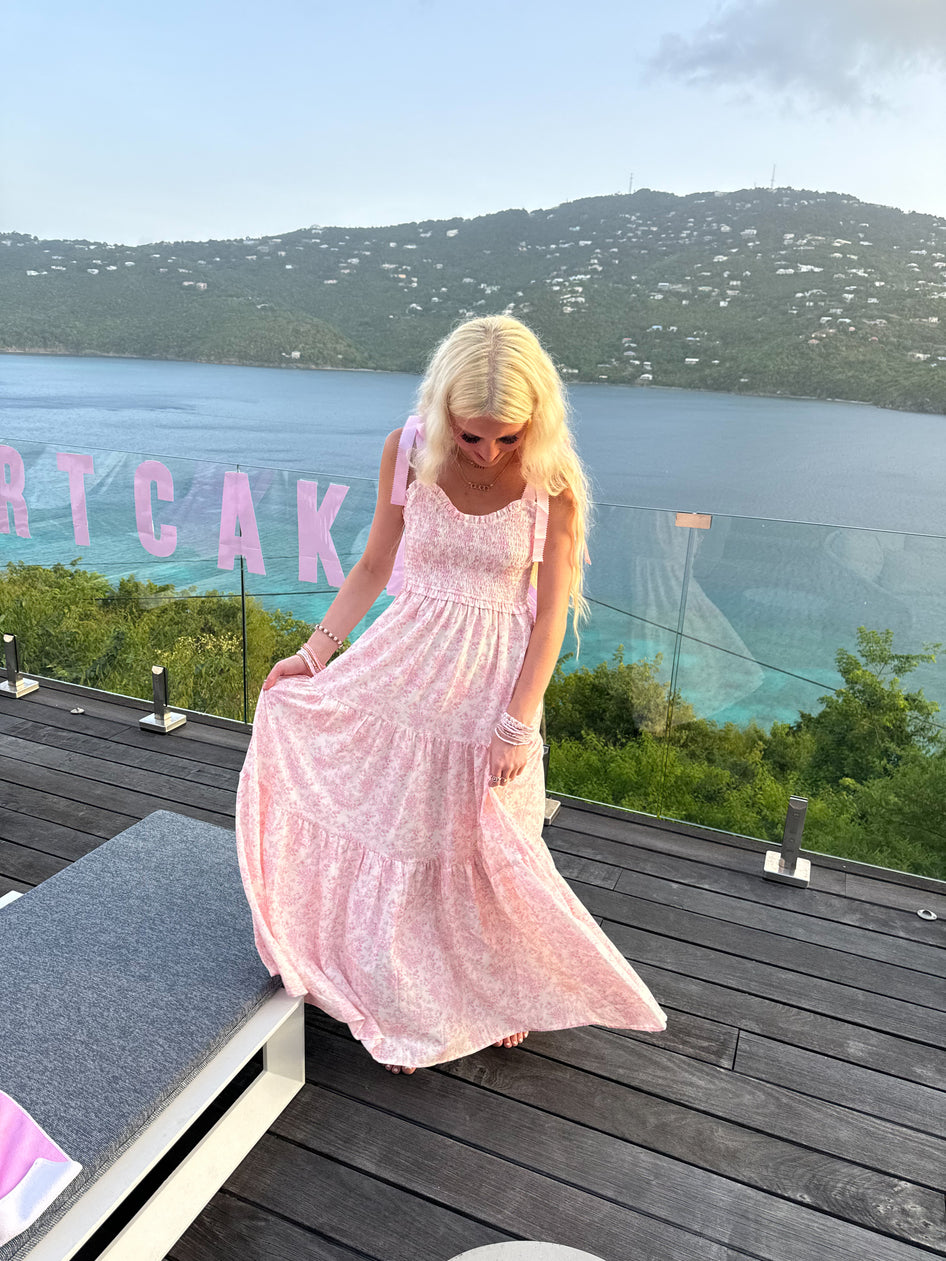 Sassy Shortcake Sweet Pea pink floral maxi styled with bracelets and sandals on a balcony — lightweight romantic summer dress.