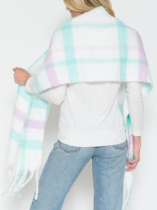 Soft, fringed pastel plaid scarf draped over shoulders; light mint, lavender, and white pattern.