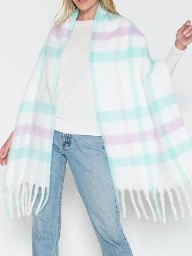 Fuzzy pastel plaid scarf with fringe, worn over jeans.