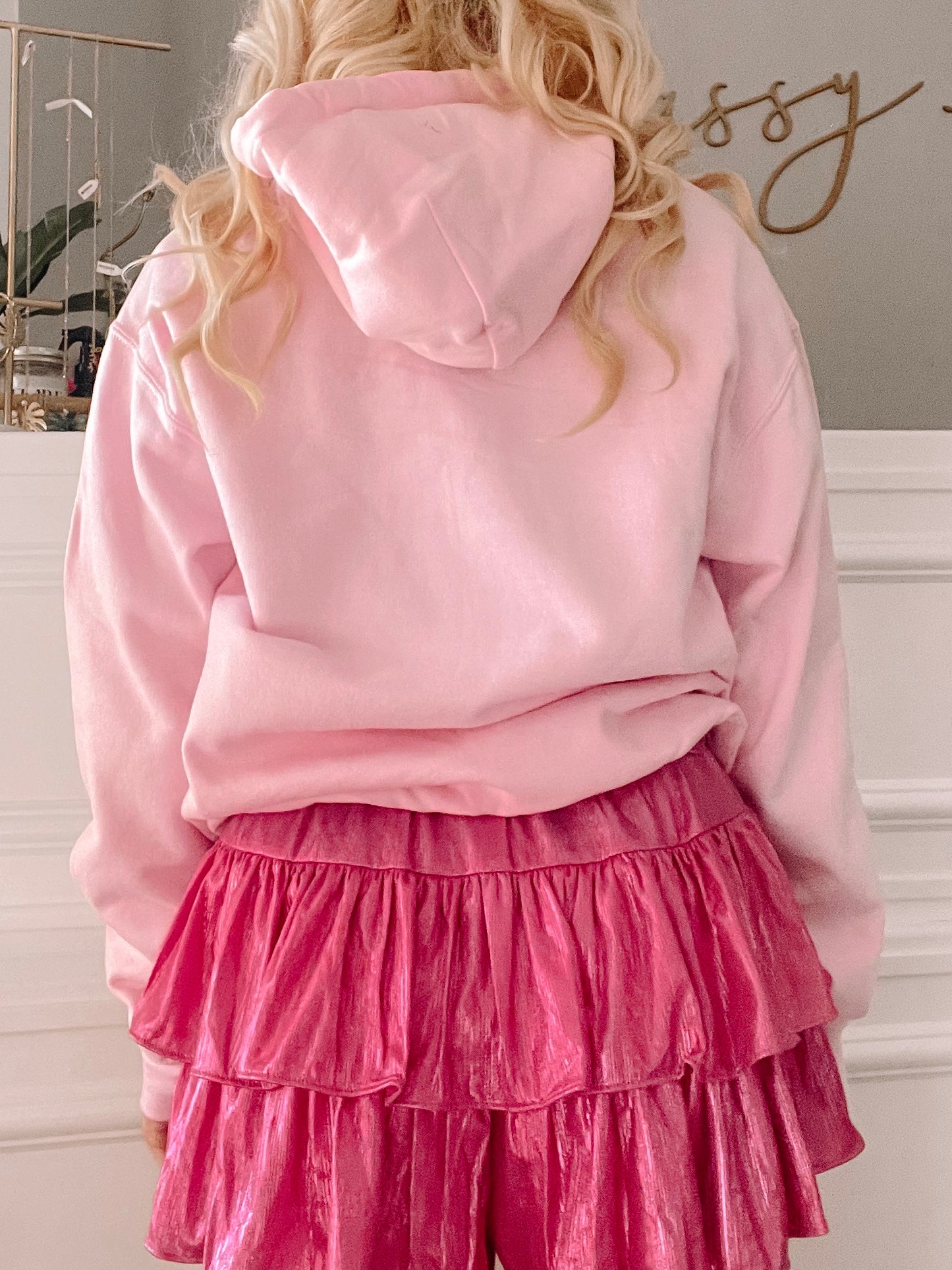 Pink hoodie with a relaxed fit paired with a fuchsia ruffled mini skirt.
