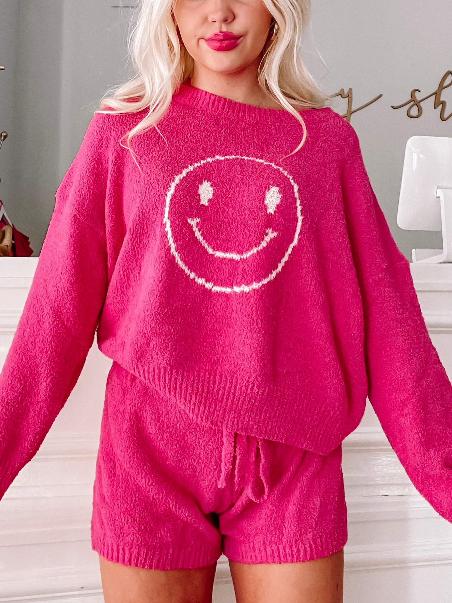 Fuzzy hot pink sweater and shorts set featuring a smiling face; cozy loungewear.