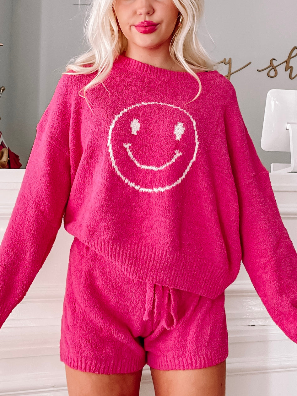 Fuzzy hot pink sweater and shorts set featuring a smiling face; cozy loungewear.