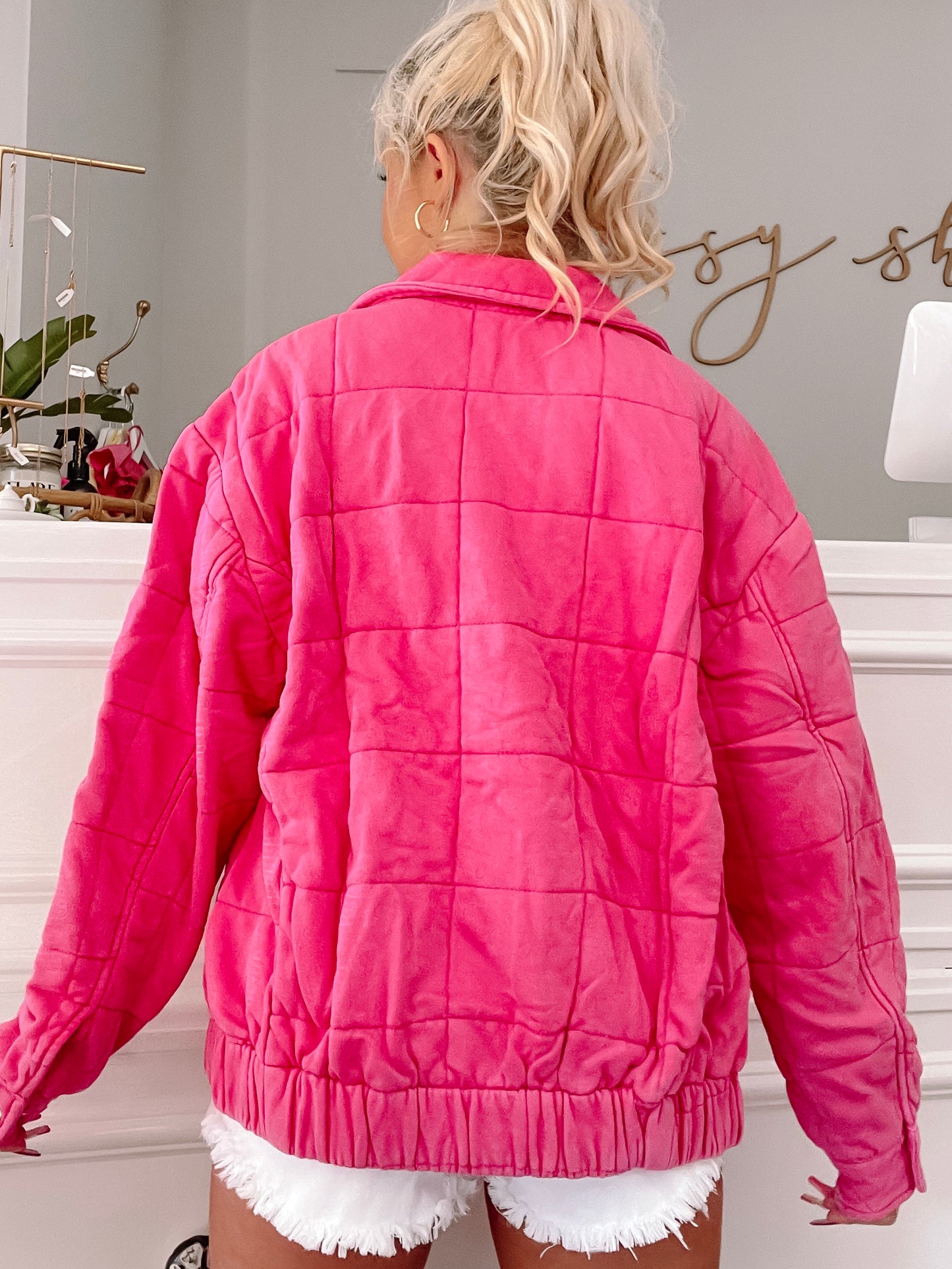 Hot pink quilted jacket, back view, showcasing the square stitching detail.