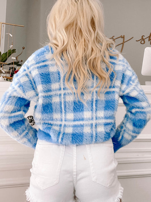 Fuzzy light blue cardigan with a white plaid pattern, shown from the back.
