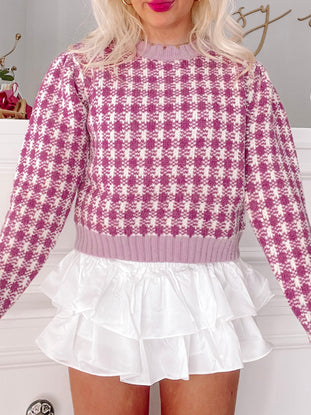Purple gingham knit sweater paired with a white ruffle skirt.