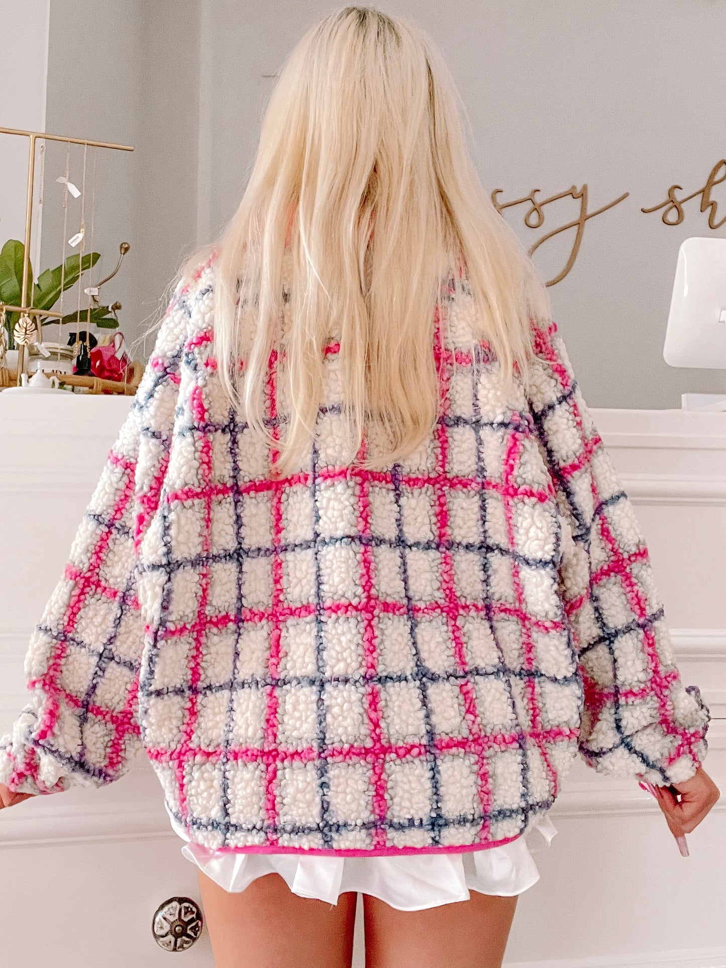 Cream-colored teddy jacket with pink and gray plaid pattern, shown from the back.