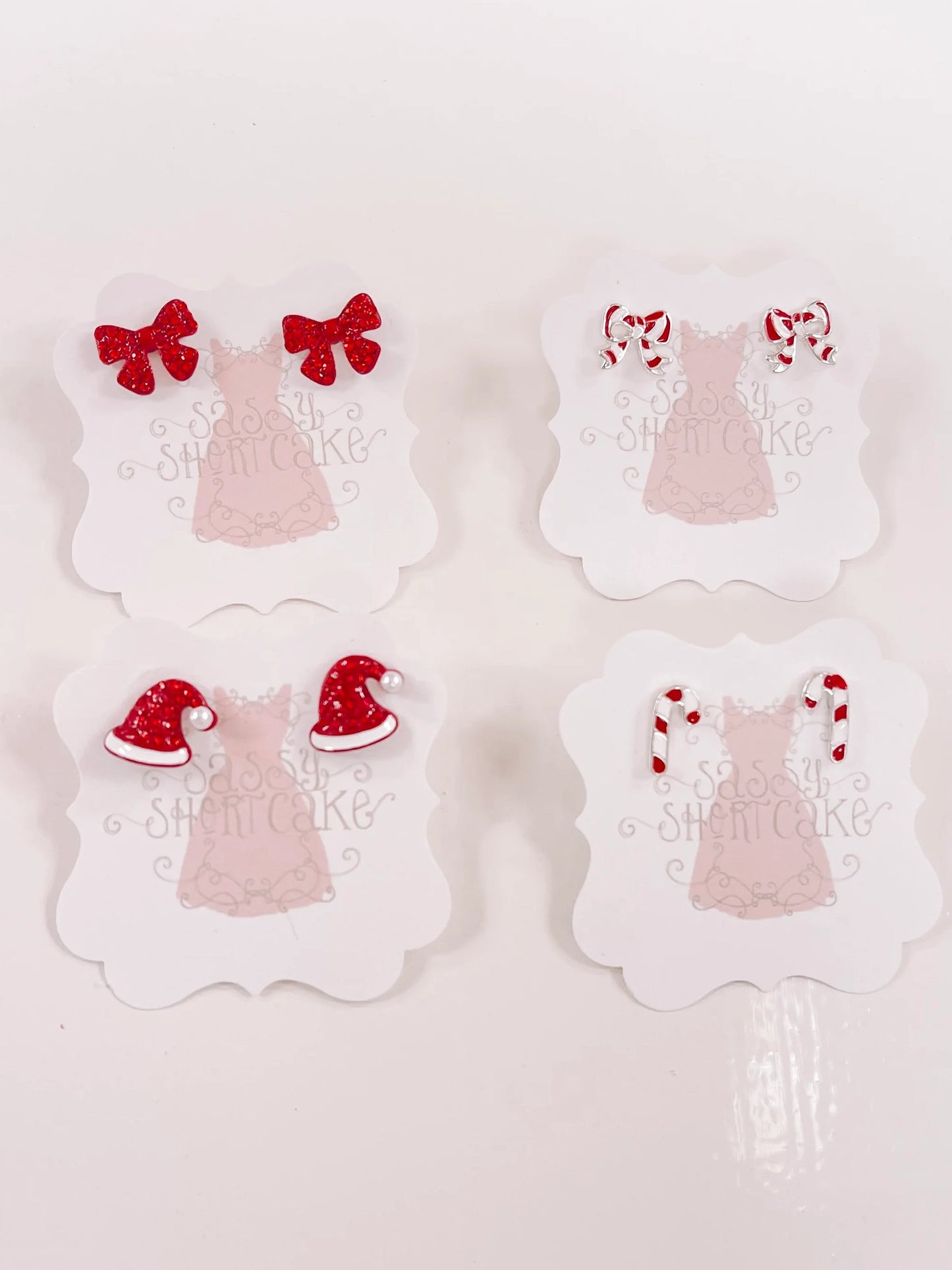 Red and white holiday-themed miniature earrings displayed on cards.