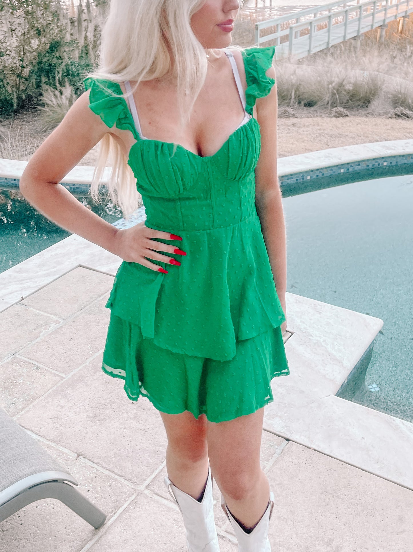 Green tiered mini dress by the pool; ruffled straps and sweetheart neckline.