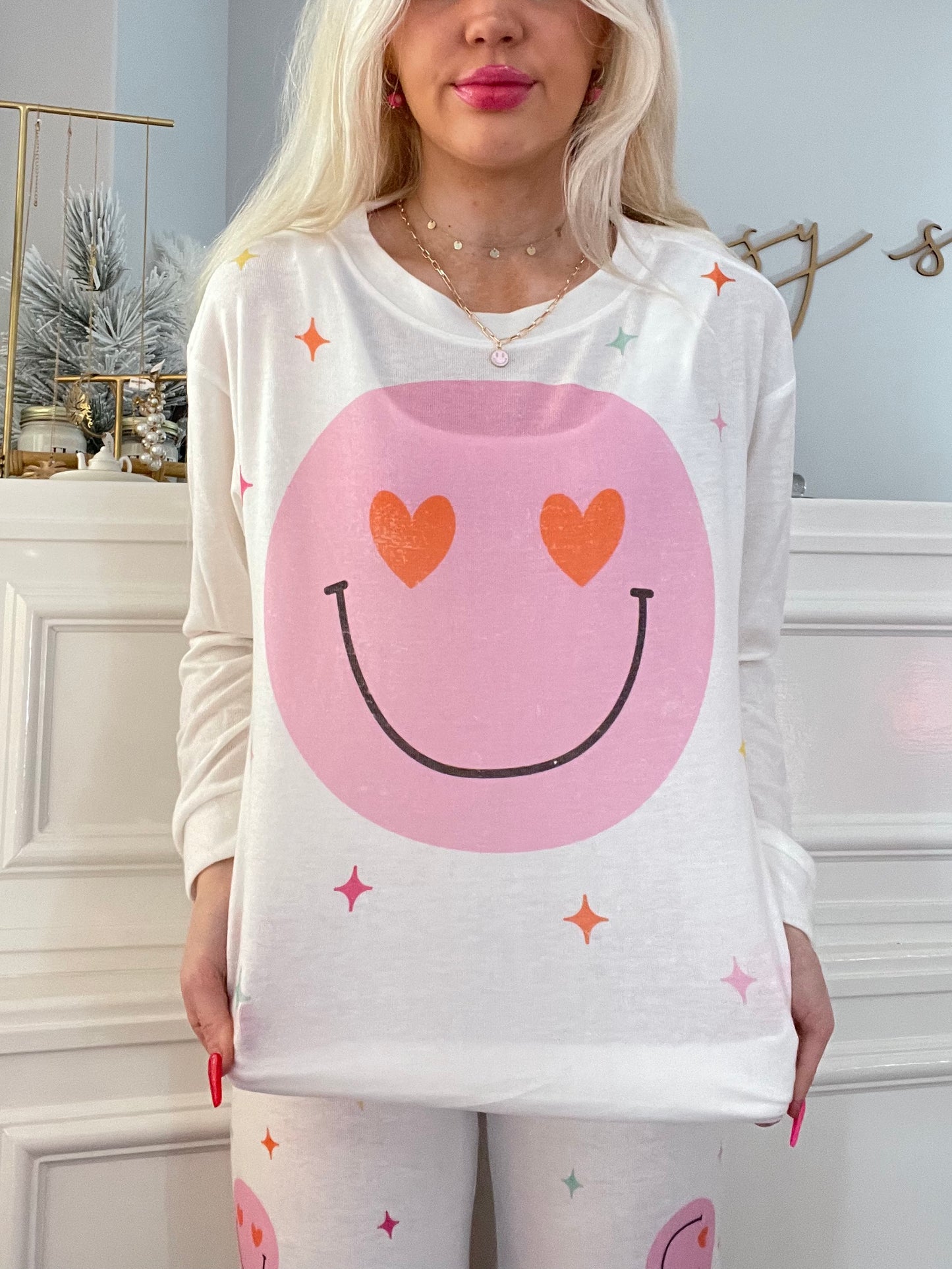 White pajama top featuring a pink smiley face with heart eyes, accented with pastel stars.