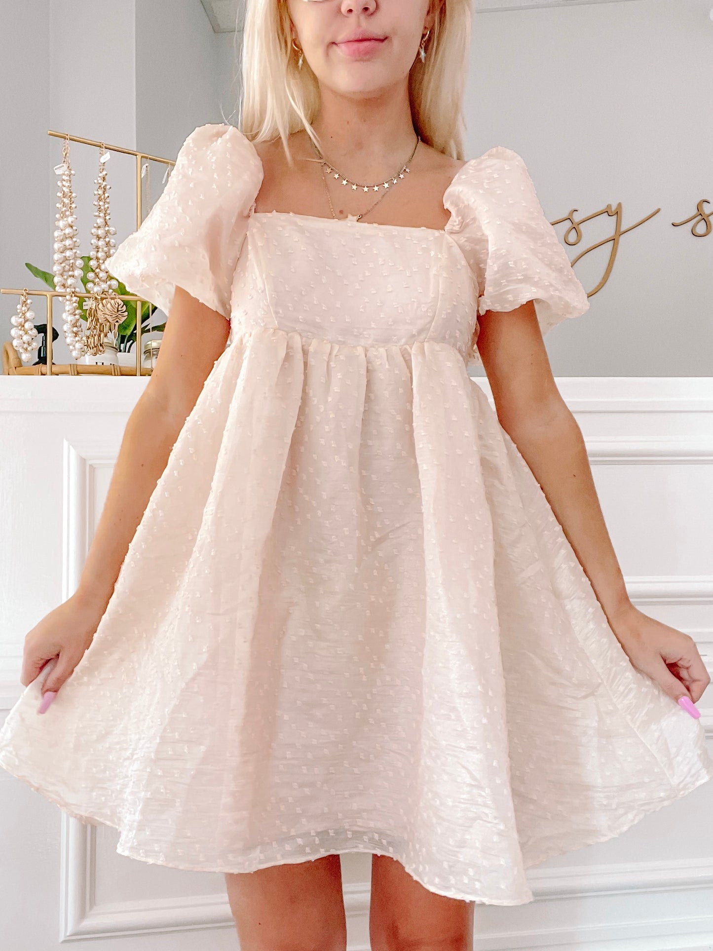 Cream eyelet mini dress with puff sleeves, shown on a model.