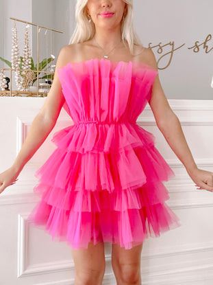 Hot pink tulle mini dress with tiered ruffles; strapless, perfect for parties.