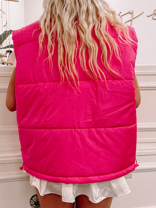 Hot pink puffer vest viewed from behind, showcasing its quilted texture and cinched hem.