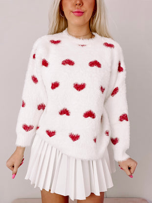 White fuzzy sweater with red heart pattern, perfect for Valentine's Day.