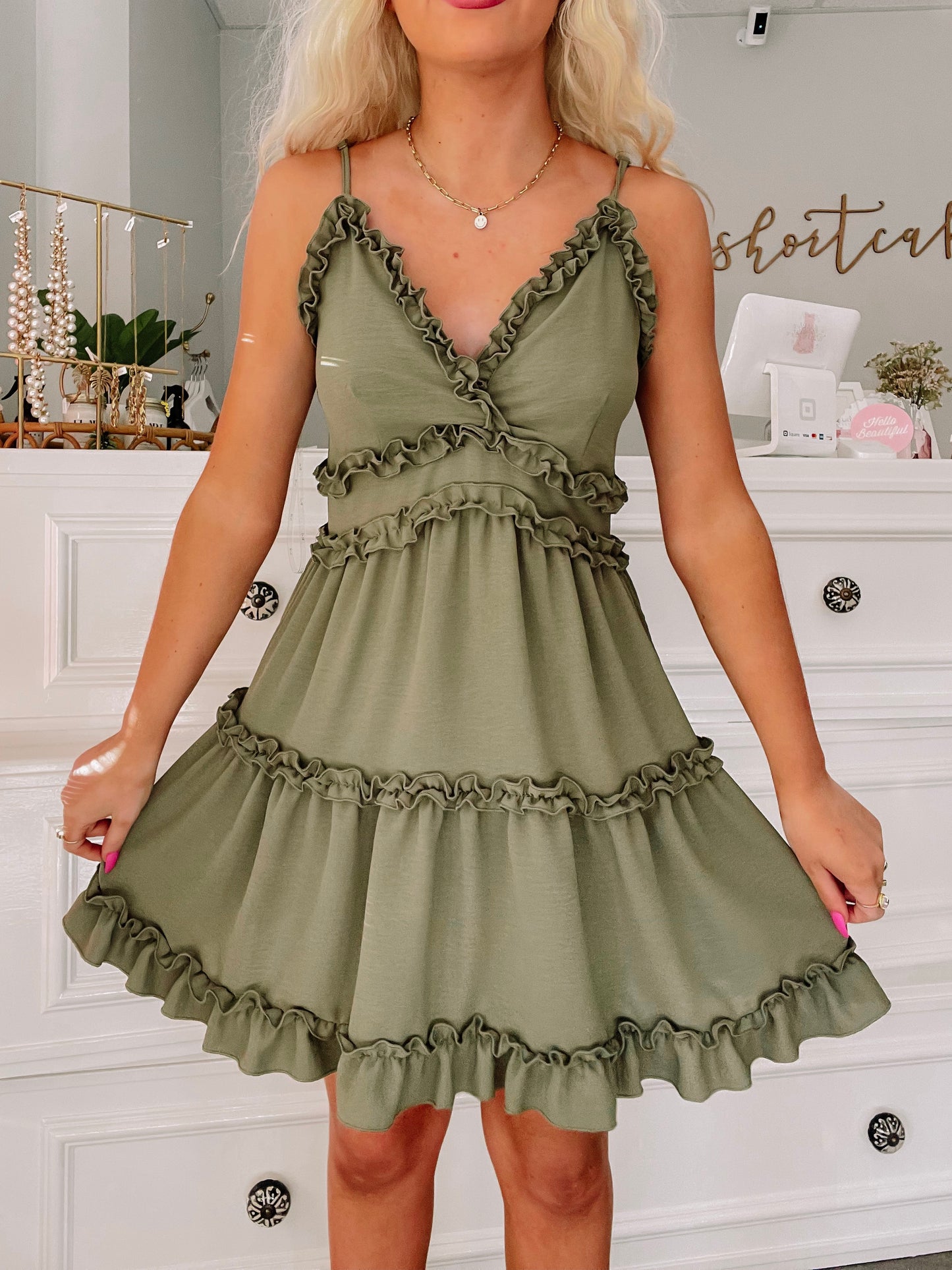 Olive green ruffle mini dress with tiered ruffles and adjustable straps.