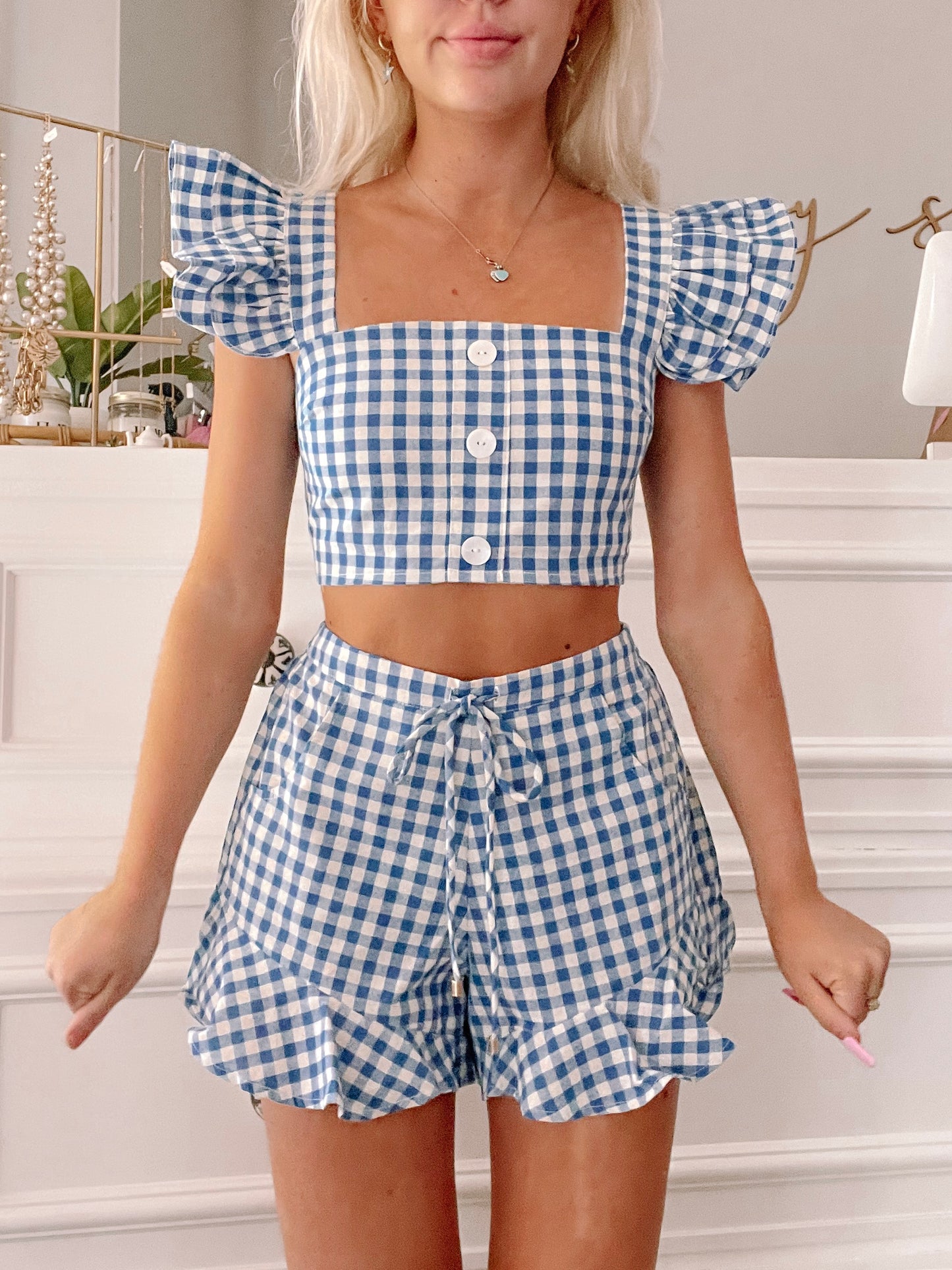 Blue gingham crop top and shorts set with ruffle trim, showcased indoors.