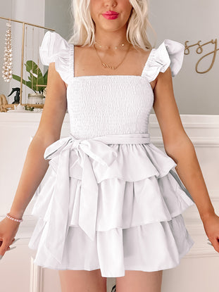 White tiered mini dress with ruffle sleeves and a self-tie belt.
