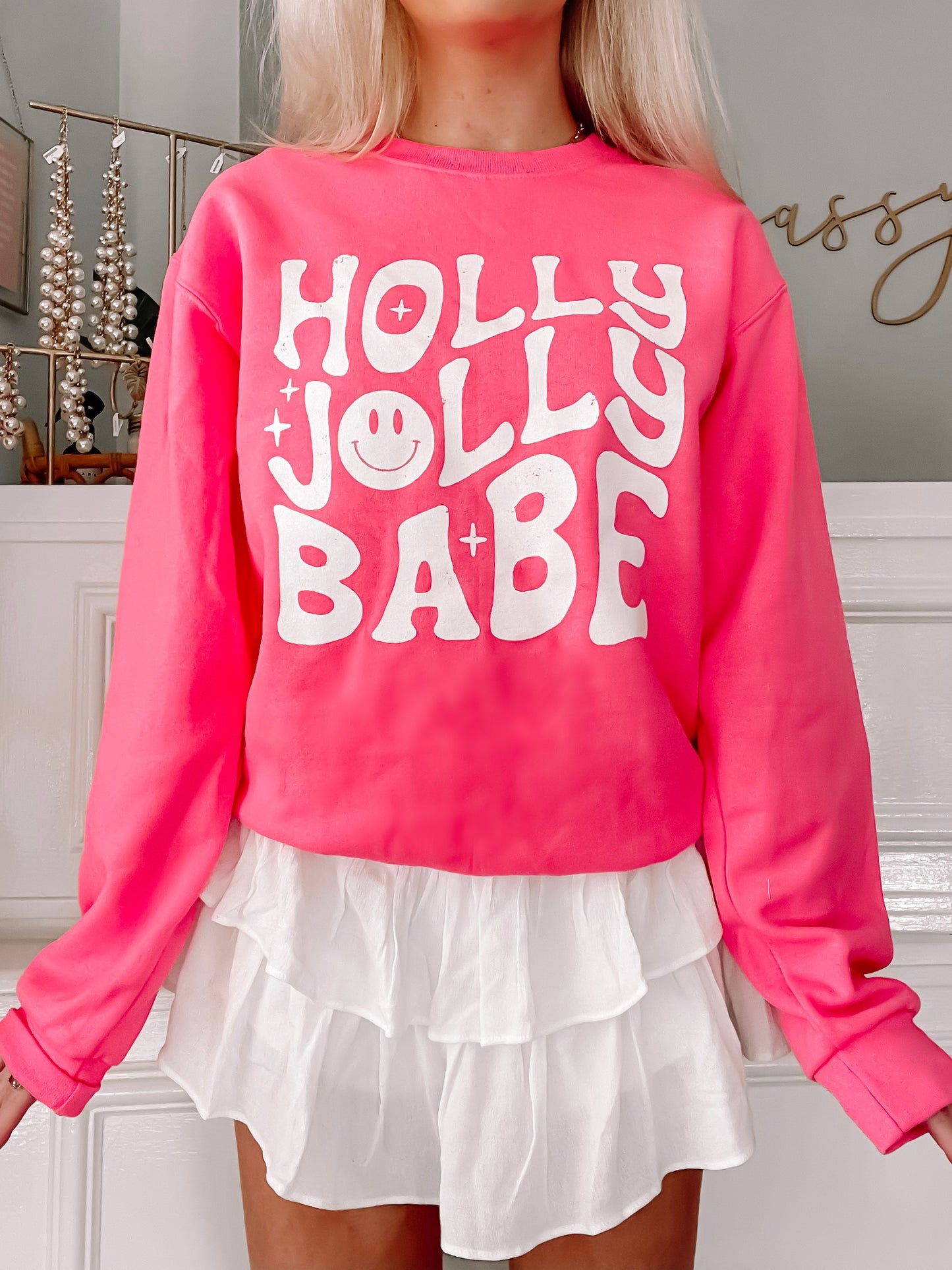 Hot pink sweatshirt with a playful "Holly Jolly Babe" design, featuring a smiley face.