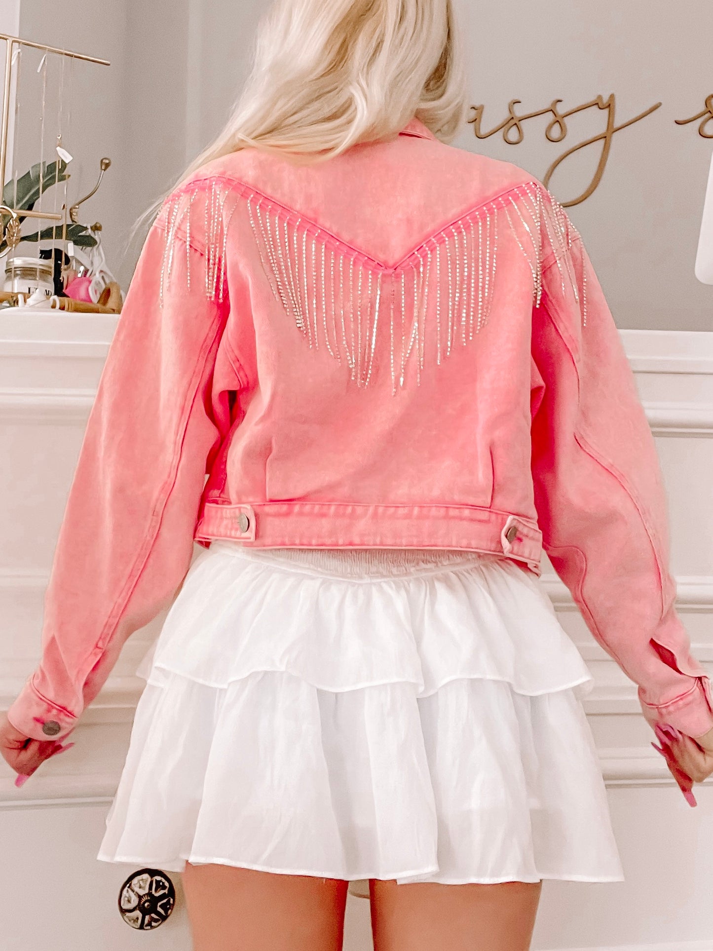 Pink denim jacket with rhinestone fringe, back view.