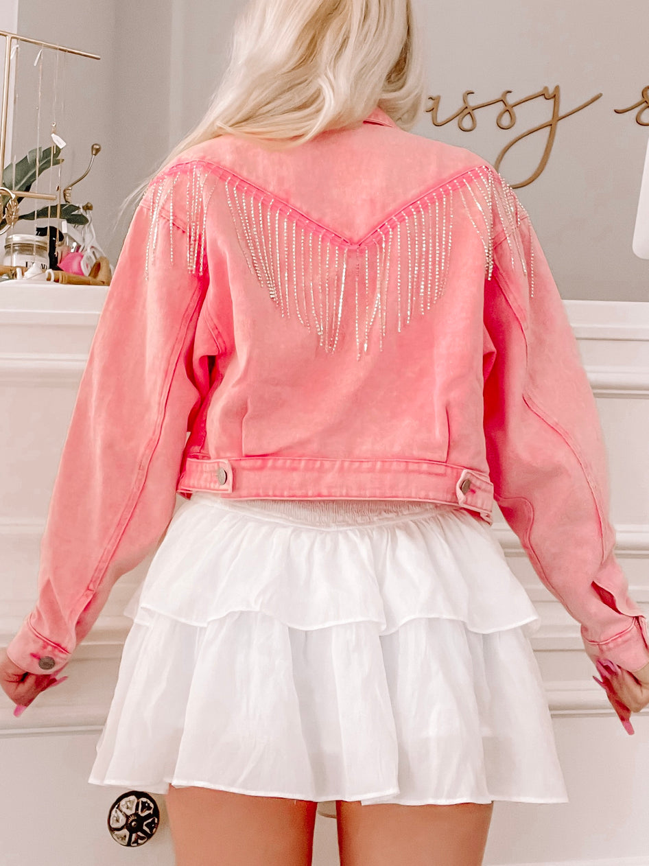 Pink denim jacket with rhinestone fringe, back view.