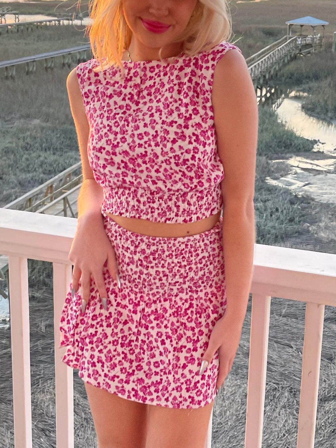 Woman wearing pink floral print Wild About You Set two-piece outfit and pink boots from Sassy Shortcake