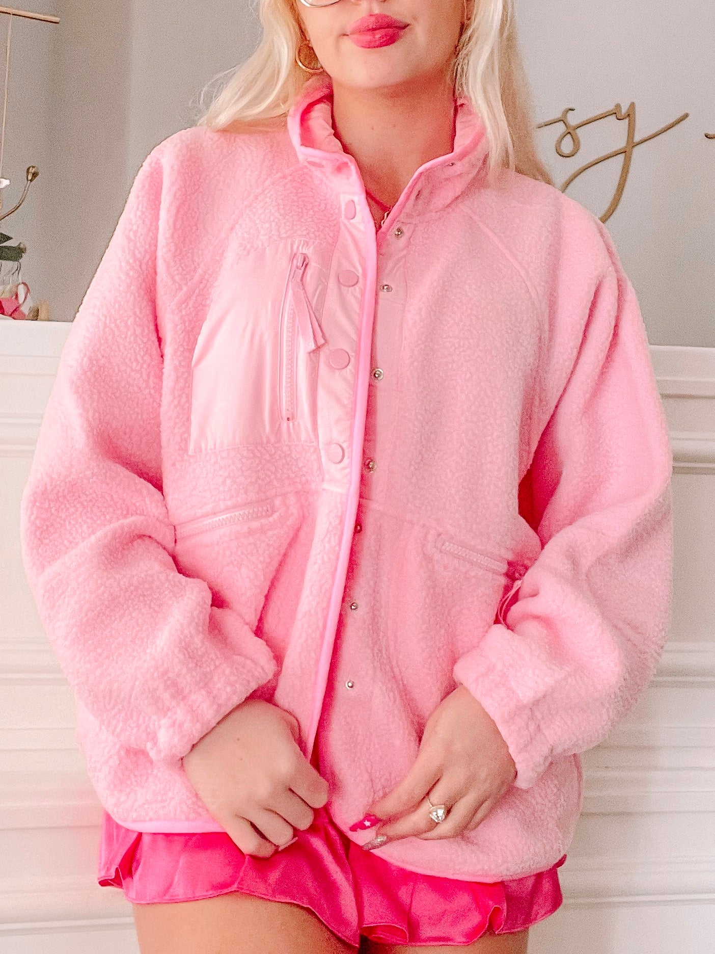 Bubblegum pink fleece jacket with snap button closure, shown on model.