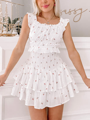 White floral two-piece outfit; ruffled skirt and cropped top.