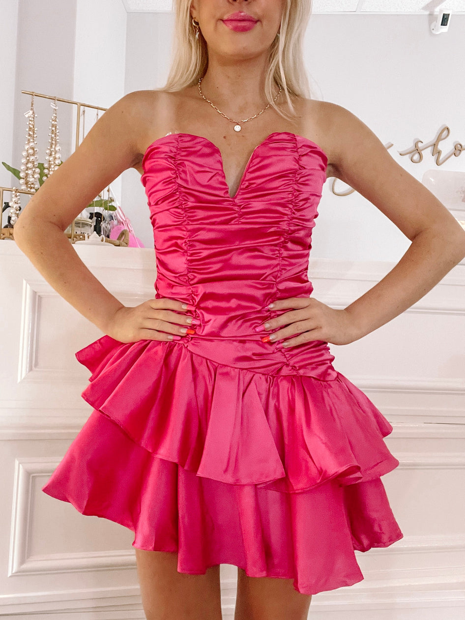 Hot pink satin mini dress with a ruched bodice and layered ruffle skirt.